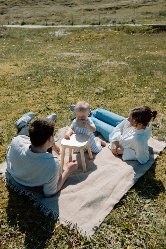 Bilde av mor, far og en liten gutt som sitter p&aring; et piknikpledd sammen, tatt av en fotograf i Rogaland